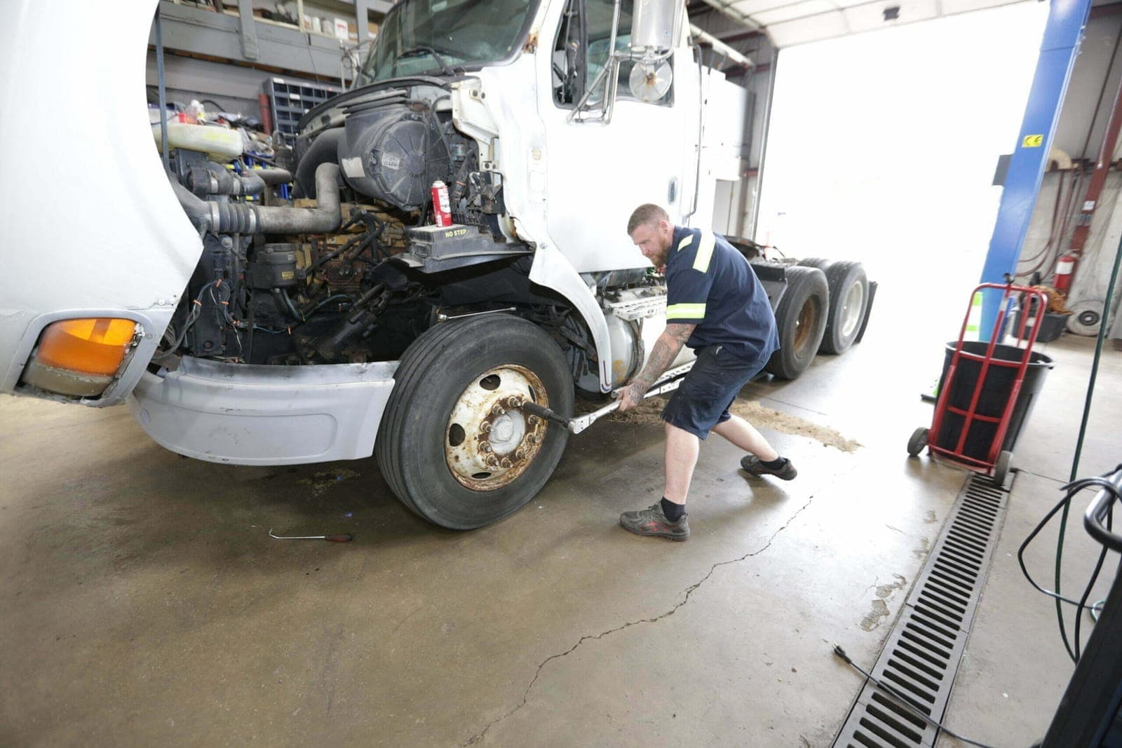 Technician repairing a semi-truck engine